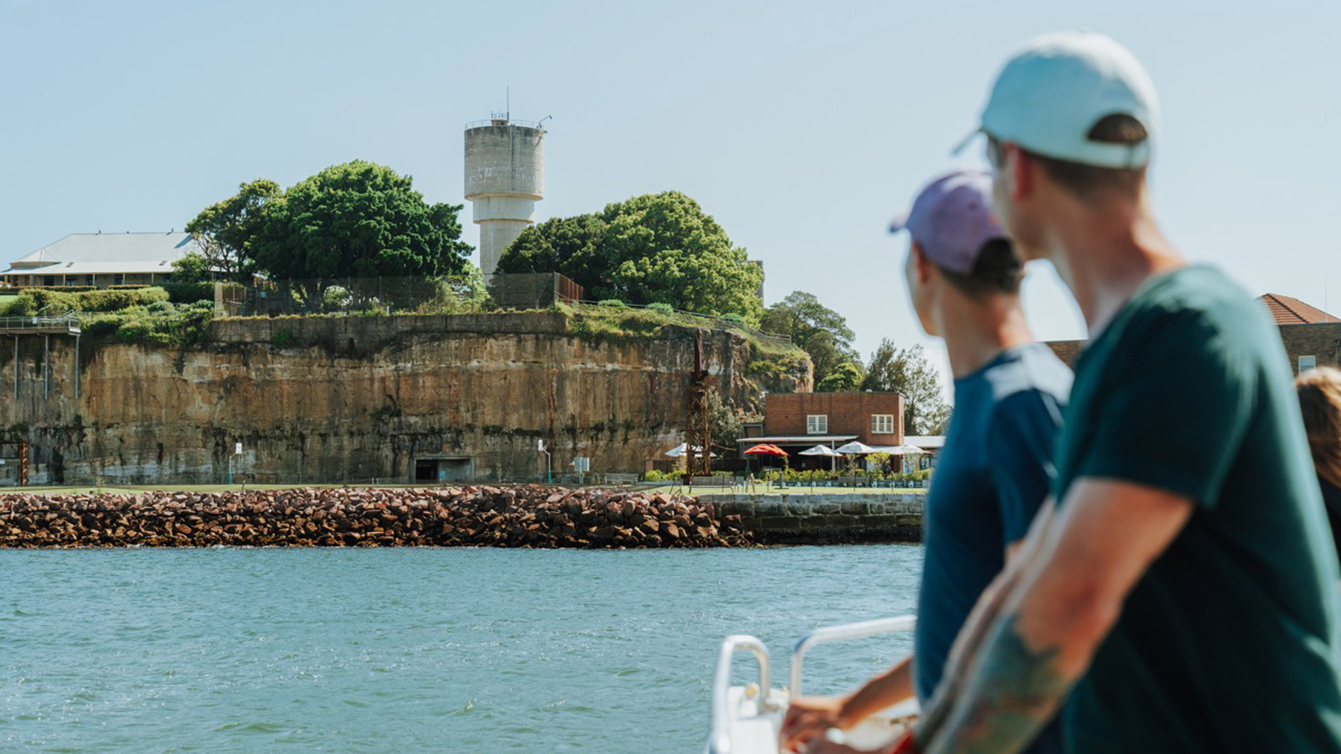 Couple on the ferry in Sydney Harbour looking at Cockatoo Island / Wareamah.