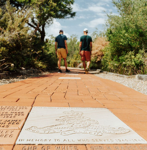 Couple walking along Australia's Memorial Walk paved pathway at North Head Sanctuary. 